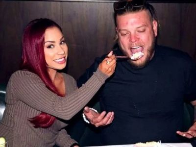 Charlene Harrison is feeding something with the spoon to Corey Harrison.